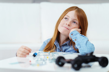 kleines mädchen baut ein spielzeugauto zusammen