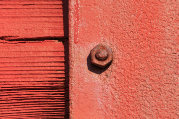 Red grunge nut and bolt with focus only on one nut