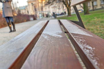 Fototapeta premium Little snow on city wooden bench in Warsaw
