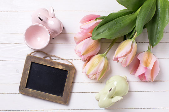 Spring  pink  tulips, decorative rabbits  and empty  blackboard