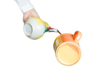 Obraz na płótnie Canvas Hand pouring tea from teapot