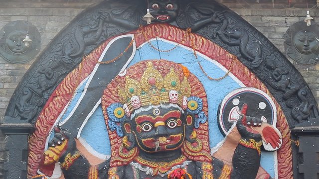 Bird takes the offerings from the mouth of idol