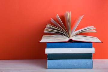 Open hardback book on wooden deck table and red background
