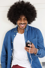 Cool guy smiling with mobile phone and earphones
