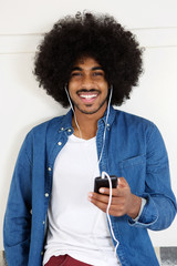 Smiling black guy listening to music on smart phone