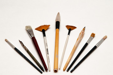 Artists brushes and pens displayed on isolated white background