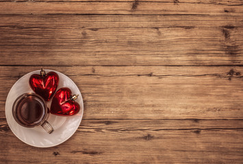 Cup tea and two hearts on wooden background