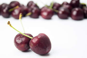 A closeup couple of cherries and group of cherries on background