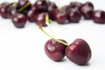 A closeup couple of cherries and group of cherries on background