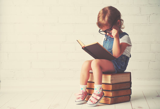 Child Little Girl With Glasses Reading A Books