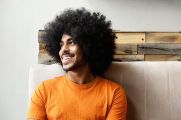 Smiling young black man with afro looking away