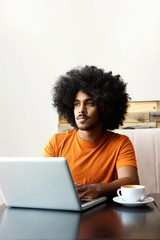 Young man sitting at table with laptop