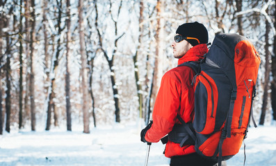 Man hiking at winter mountain/Man hiker trekking in snow forest at winter mountain. Healthy lifestyle winter adventure