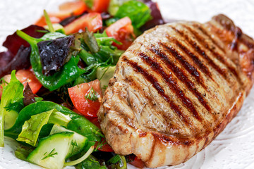 Grilled pork meat and vegetables on plate
