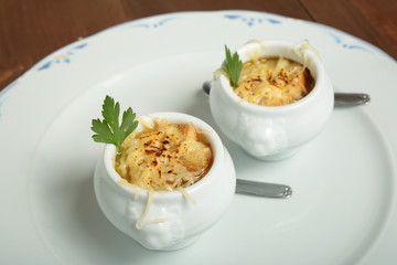 Onion soup served in porcelain bowls
