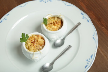 Onion soup served in porcelain bowls
