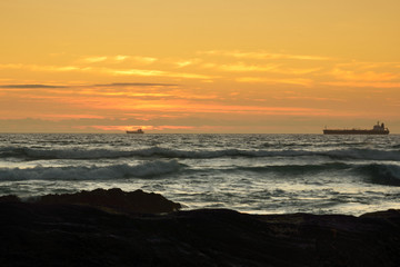 Fototapeta premium Ozean mit der Silhouette von 2 Schiffen zum Sonnenuntergang