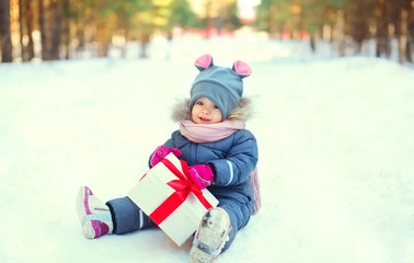 Fototapeta na wymiar Cute child with christmas box gift in winter day