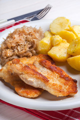 Fried chicken breast fillet on a white plate.