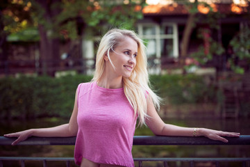 Beautiful young blonde woman on a walk arownd the city near to the castle in summer sunny day