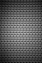 Abstrakte Kreise und Sterne / Die Draufsicht auf eine abstrakt schwarz und weiß gemusterte Metalloberfläche.