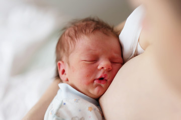 One day old newborn baby with mother