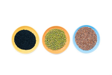 Three bowls with different seeds on white background