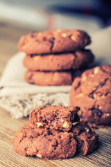 Chocolate biscuit cookies. Chocolate cookies on white linen napkin on wooden table.