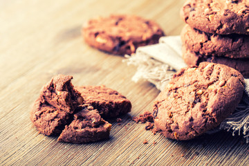 Chocolate biscuit cookies. Chocolate cookies on white linen napkin on wooden table.
