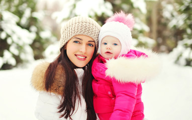 Portrait happy smiling mother and child in snowy winter day