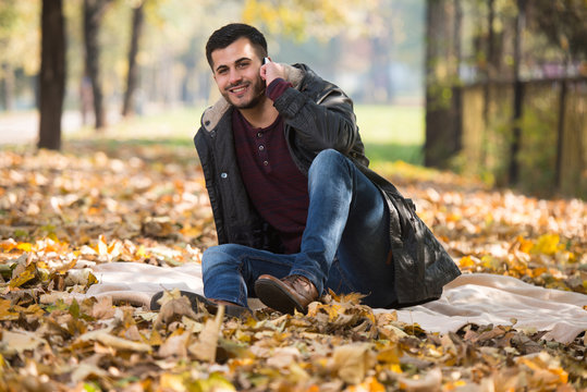 Autumn Man Talking On Mobile Phone In Fall