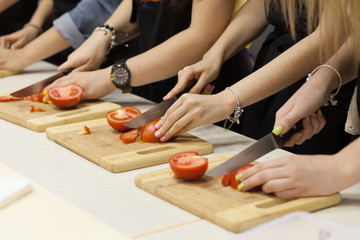Obraz na płótnie Canvas girl cut tomatoes in the kitchen
