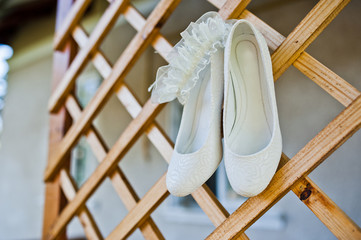 Obraz na płótnie Canvas Bride wedding shoes on a wooden grid