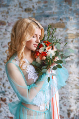 Charming young blond woman holding fresh flowers