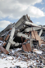 Fototapeta na wymiar Rubble pile of wrecked building, blue sky and clouds, 2015.