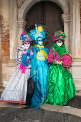 Fototapeta na wymiar Trio on colorful traditional costumes at the carnival of Venice