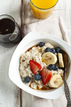 Oatmeal with berries and maple syrup. Top view