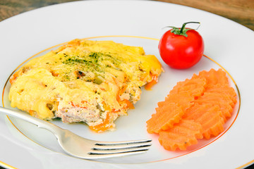 Baked salmon in cream with onions, carrots, cheese