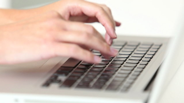 Woman’s hands typing on laptop keyboard