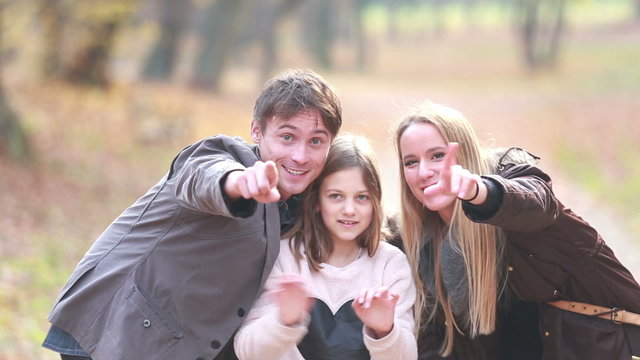Portrait of family waving in park