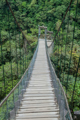 Fototapeta na wymiar Suspension bridges leading to the viewpoint on Pailon del Diablo (Devil's Cauldron) waterfall near Banos town, Ecuador
