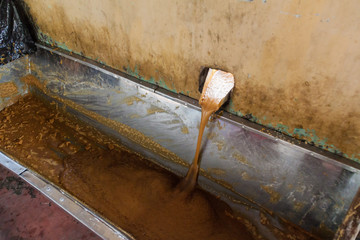 Detail of pourin of sugar cane juice. This is a part of a process of producing panela (unrefined whole cane sugar) in Colombia