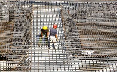 worker in the construction site making reinforcement metal frame