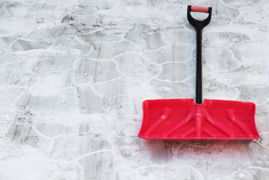 .Red plastic shovel for snow removal.