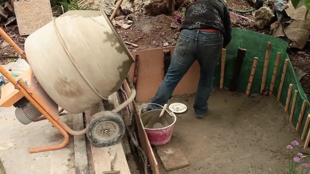 Video clip of mason reinforcing the fresh cement during the construction of artificial pond in the garden.