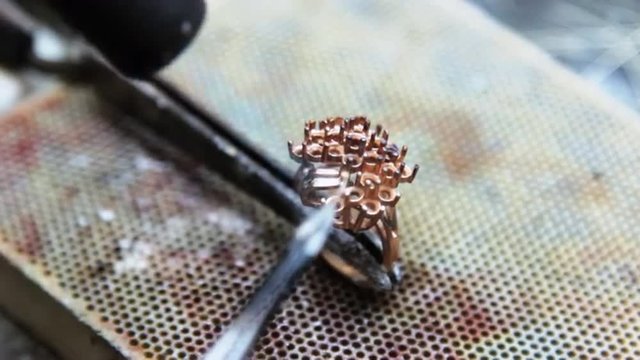Assembly, soldering pieces of gold jewelry jeweler. Production and making manufacturing, factory, cast craft design, process precious gold jewelry, diamond, jewels, ring jeweler, goldsmith in workshop