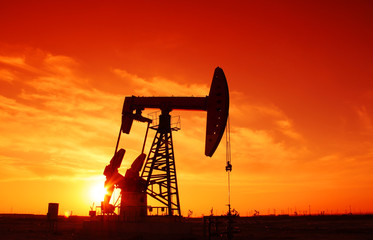 Oil field scene, the evening of beam pumping unit in silhouette