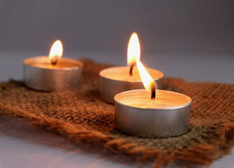 Fototapeta na wymiar burning candles on sack cloth