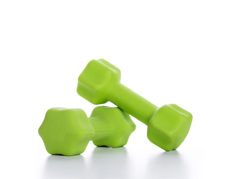 Fitness concept with two green dumbbells on white background