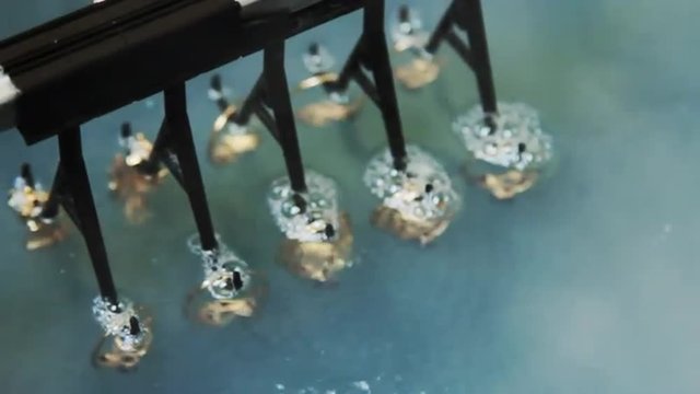 Electrochemical treatment of gold jewelry. Production and making manufacturing, factory, cast craft design, process precious gold jewelry, diamond, jewels, ring jeweler, goldsmith in workshop.